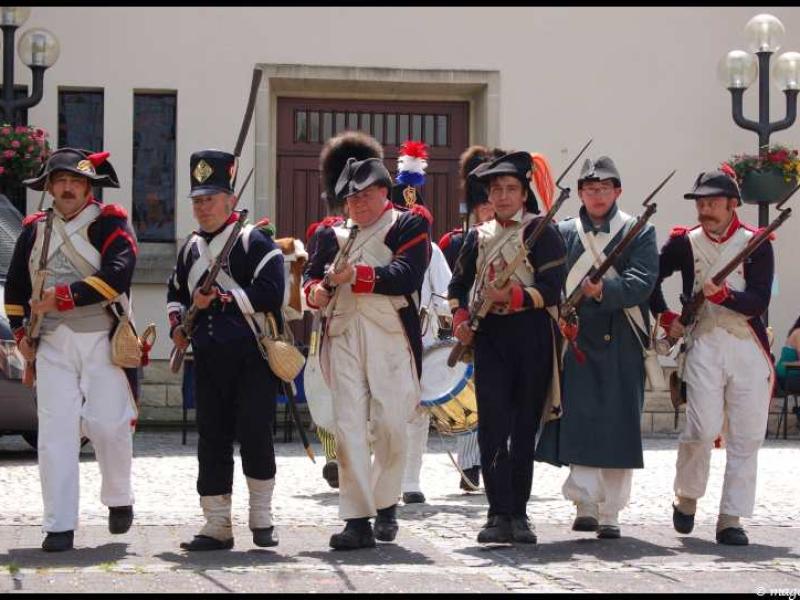 Napoleonic Bivouac в Люксембурге: солдаты в мушкетах и фуражках на каменной улице