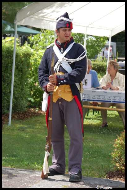 Napoleonic Bivouac в Люксембурге: солдат в мундире 1812 года с ружьём и белым шарфом