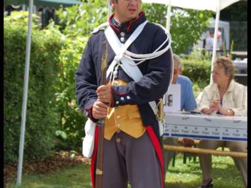 Napoleonic Bivouac в Люксембурге: солдат в мундире 1812 года с ружьём и белым шарфом