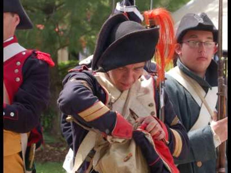 Napoleonic Bivouac в Люксембурге: солдат в темно-синей форме с красным шарфом и пистолетом