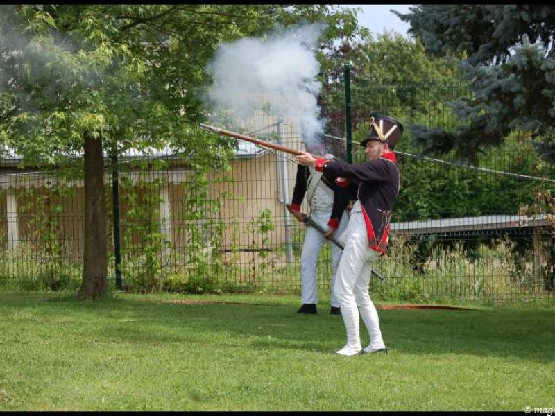 Napoleonic Bivouac в Люксембурге: солдат в чёрно-красной форме стреляет из мушкета