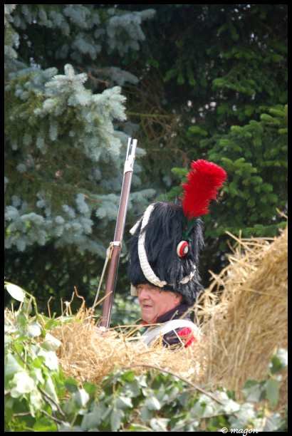 Napoleonic Bivouac в Люксембурге: солдат в шляпе с красным плюмажем за стогом сена