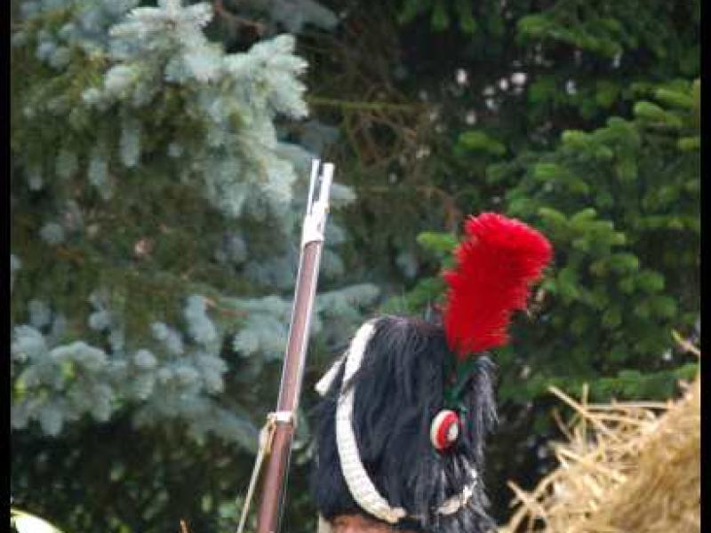 Napoleonic Bivouac в Люксембурге: солдат в шляпе с красным плюмажем за стогом сена