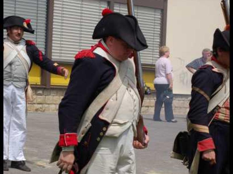 Napoleonic Bivouac в Люксембурге: солдаты в мундирах эпохи Наполеона у здания с жёлтыми жалюзи