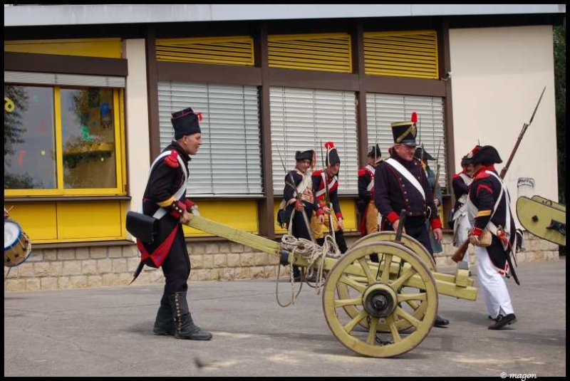 Napoleonic Bivouac в Люксембурге: солдаты с пушкой у желто-коричневого здания