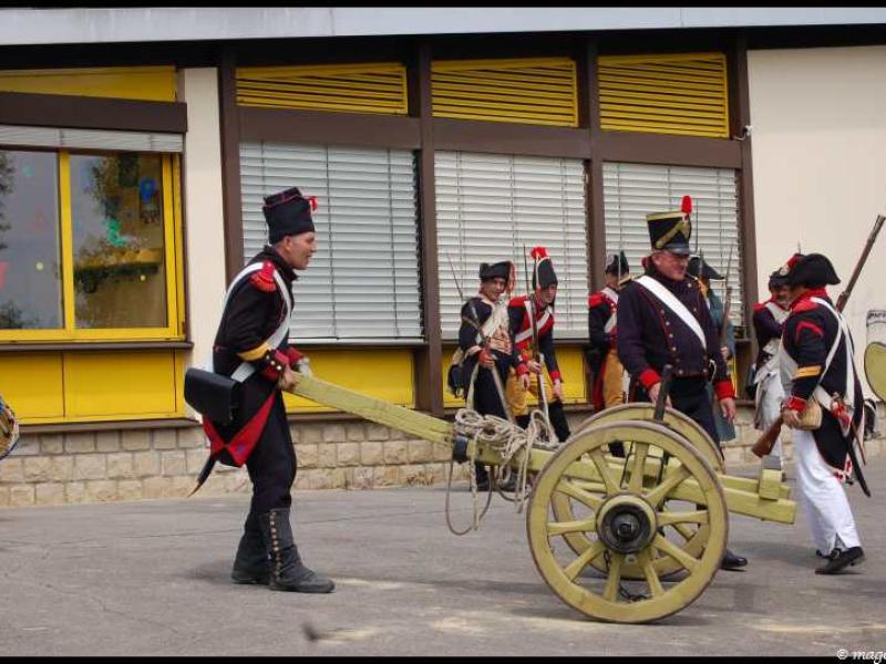 Napoleonic Bivouac в Люксембурге: солдаты с пушкой у желто-коричневого здания