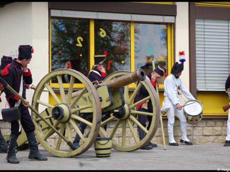 Napoleonic Bivouac в Люксембурге: пушка и барабан на улице с желтыми окнами