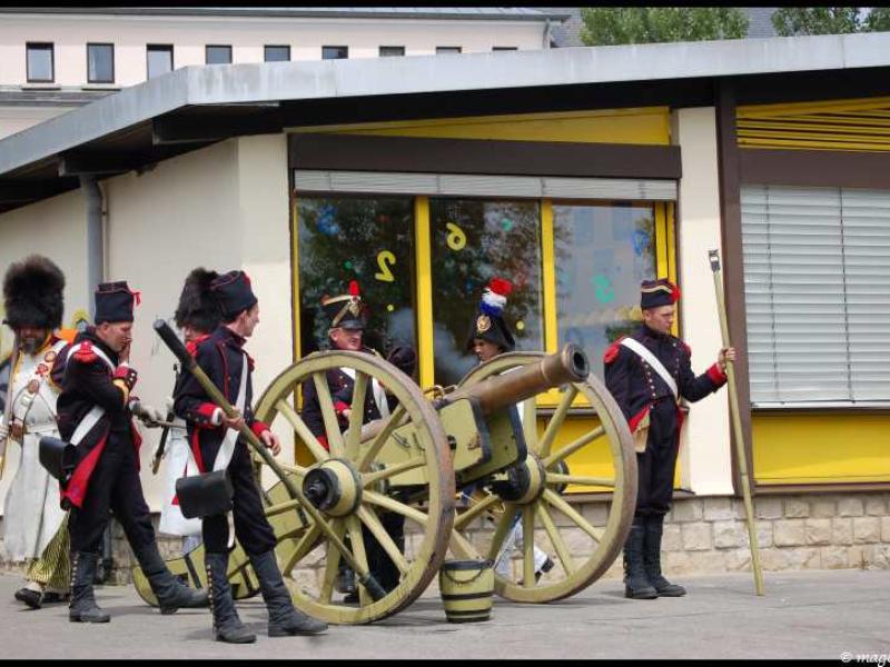 Napoleonic Bivouac в Люксембурге: солдаты у пушки у современного здания