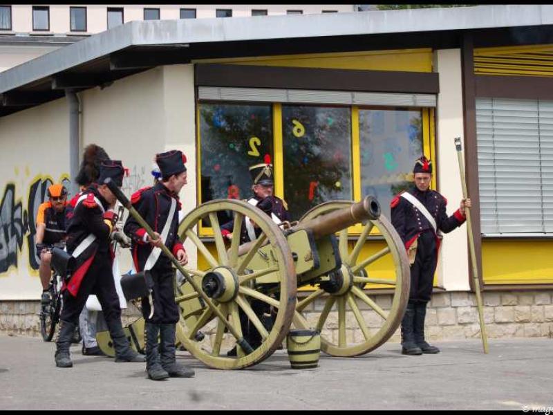 Napoleonic Bivouac в Люксембурге: солдаты с пушкой у здания с желтыми окнами