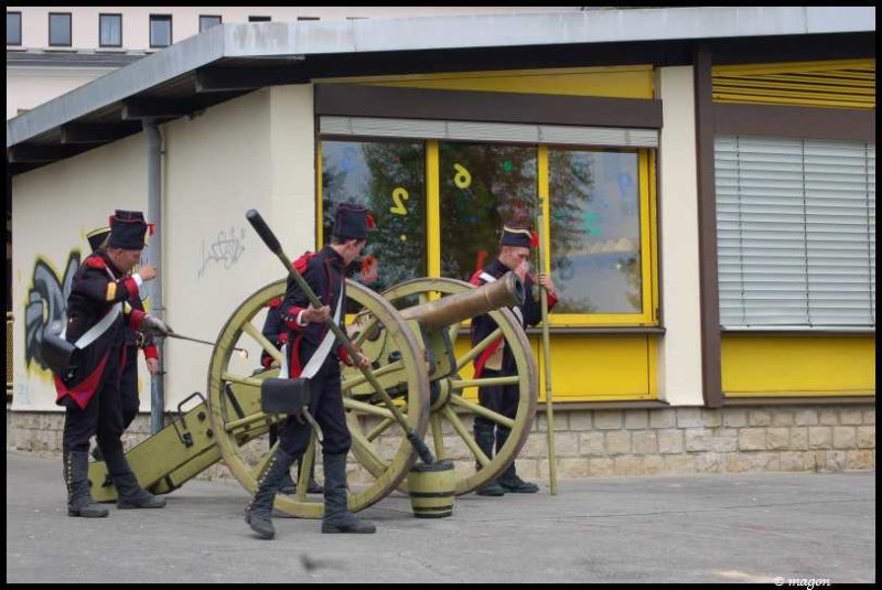 Napoleonic Bivouac в Люксембурге: солдаты у пушки у здания с жёлтыми окнами