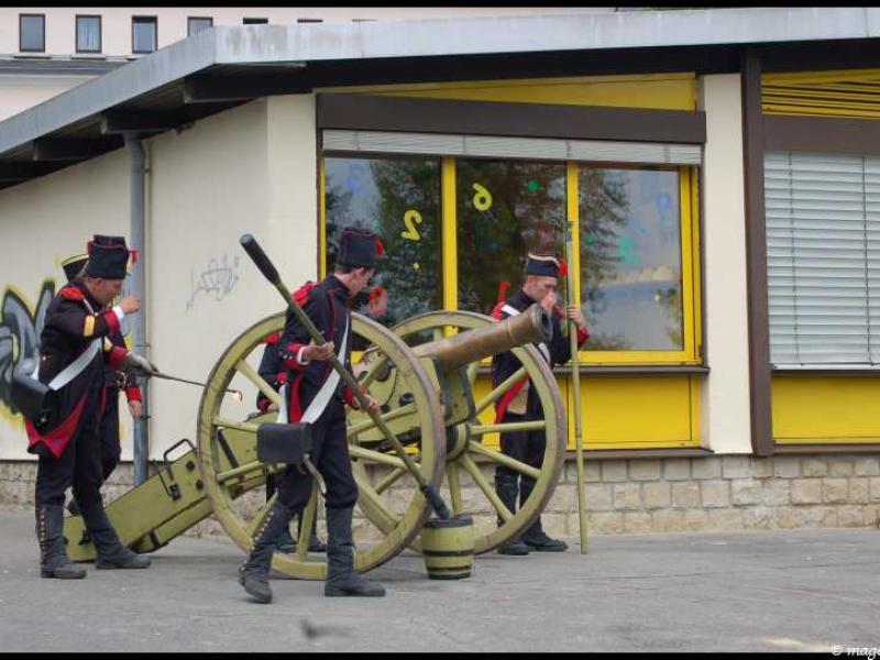 Napoleonic Bivouac в Люксембурге: солдаты у пушки у здания с жёлтыми окнами