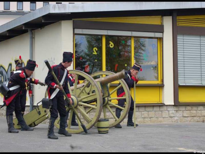 Napoleonic Bivouac в Люксембурге: солдаты у пушки на фоне желтого здания