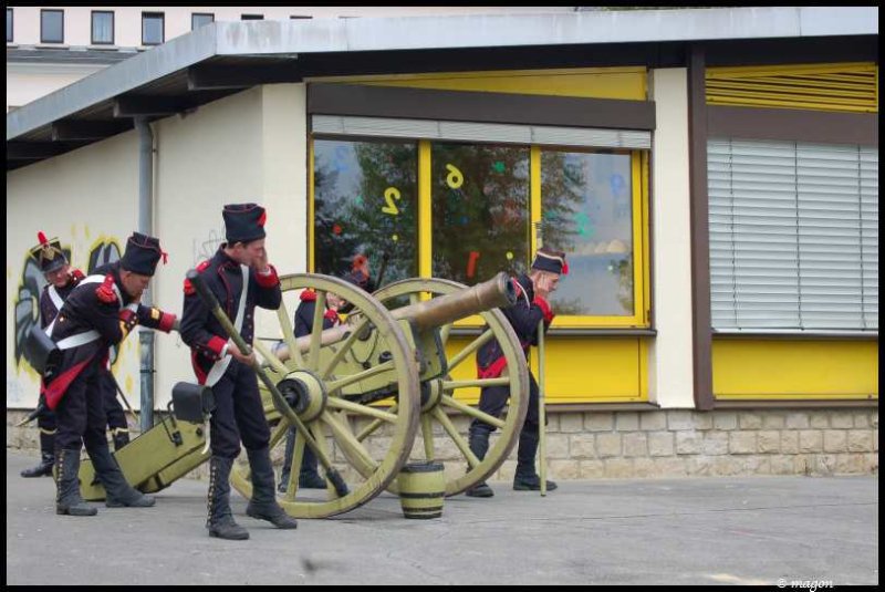 Napoleonic Bivouac в Люксембурге: солдаты у пушки у здания с желтыми окнами