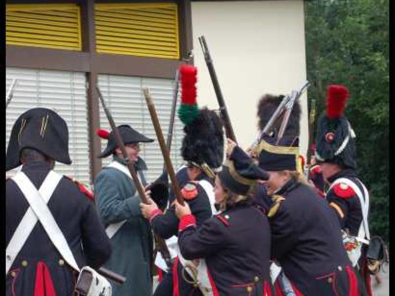 Napoleonic Bivouac в Люксембурге: сцена реконструкции боя 1812 года у современного здания с жёлтыми жалюзи