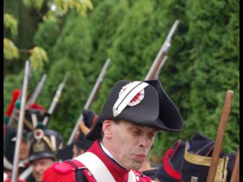Napoleonic Bivouac в Люксембурге: солдат в красно-чёрном мундире с белым шарфом