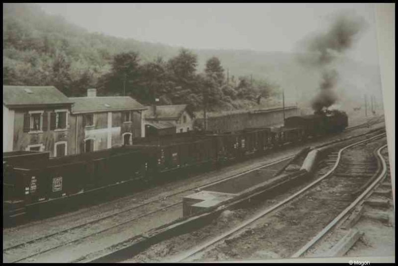 Train в Люксембурге, 1900: паровоз тянет грузовые вагоны мимо старых домов