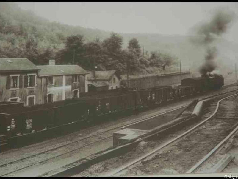 Train в Люксембурге, 1900: паровоз тянет грузовые вагоны мимо старых домов