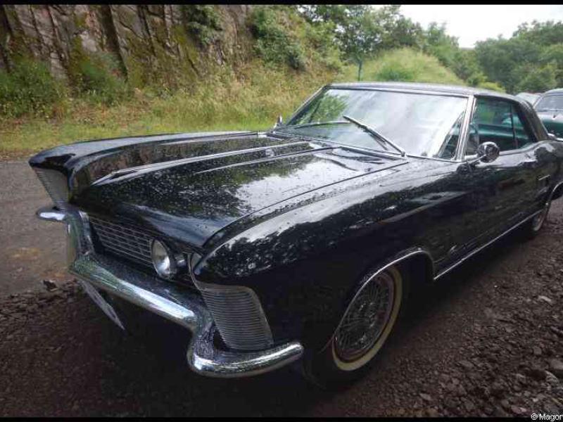 Люксембург, 20 июня 2009: чёрный Buick Riviera на гравийной парковке у скалистого склона