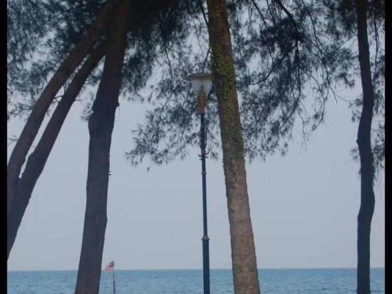 Парк у моря в Куантане: лампа, скамейка и флаг Малайзии