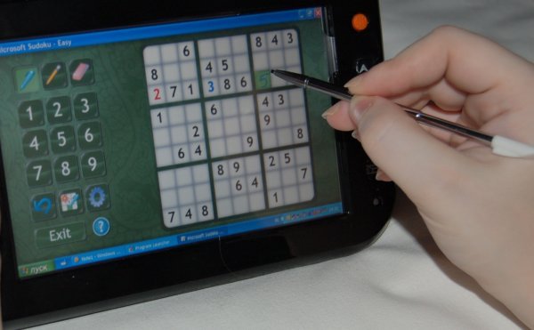Origami: рука с стилусом решает Sudoku на планшете