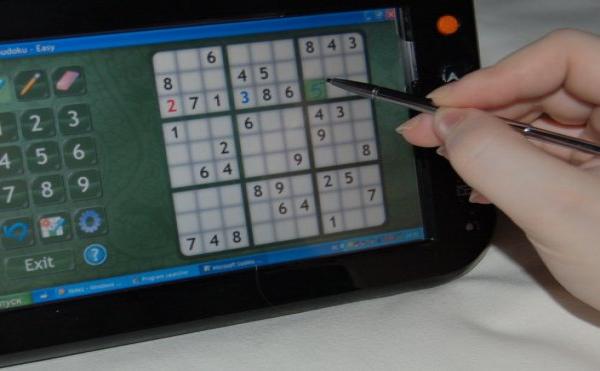 Origami: рука с стилусом решает Sudoku на планшете