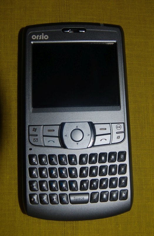 Orsio P745 на жёлтом ткани: серебристый телефон с физической клавиатурой и Windows Mobile