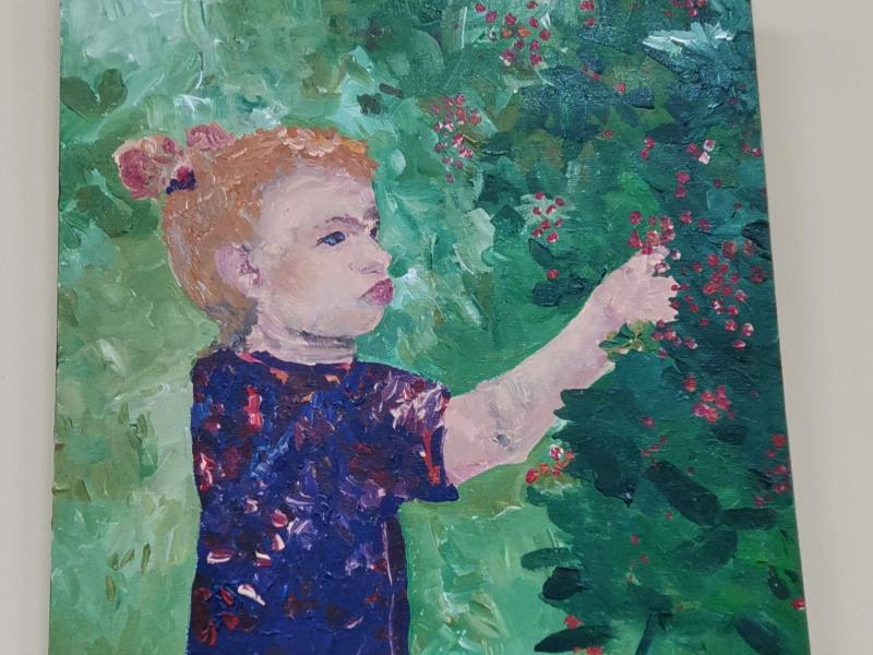 Девочка в синем платье собирает бузину у зелёного куста