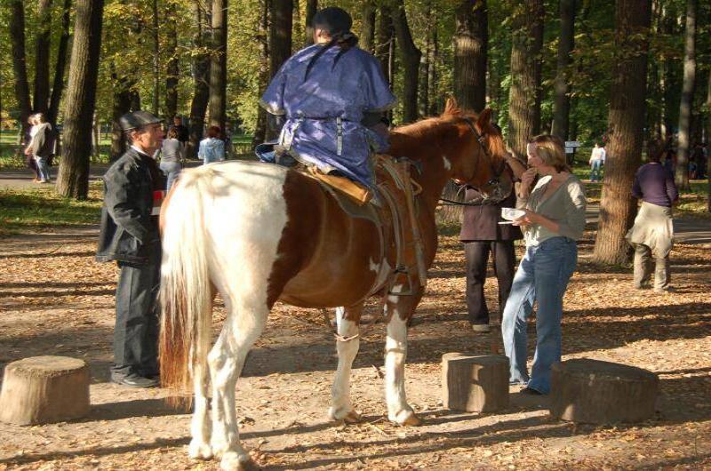 Архангельское, 2006: всадник в синем на пегой лошади среди осенних деревьев