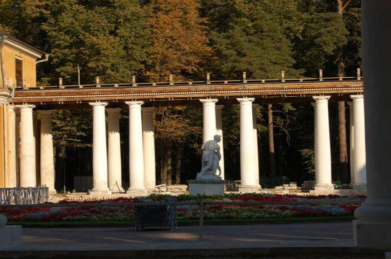 Архангельское, 2006: колоннада с белой статуей и клумбами в тени деревьев