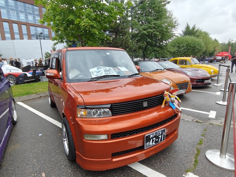 Arma120726: оранжевый Scion xB с фигурками на капоте и японским номером
