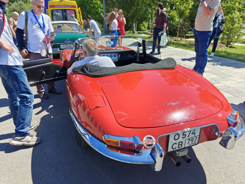 Dinamo Historic Rally: красный Jaguar E-Type на фоне зеленого Mercedes и желтого автобуса