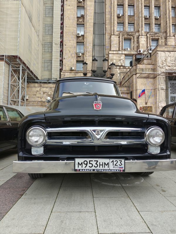 Чёрный Ford F-100 1950-х на фоне позднесоветского здания в Diplorally, 2026