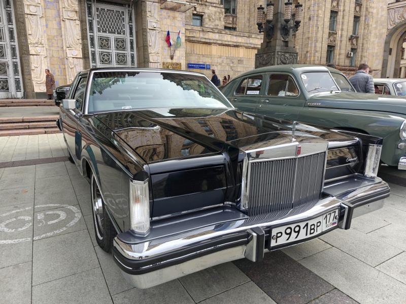 Diplorally, 26 сентября 2026: чёрный Lincoln Continental 1979 года у входа в здание с резными барельефами