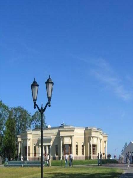Современный парковый пейзаж с классическим зданием и двойной фонарной опорой