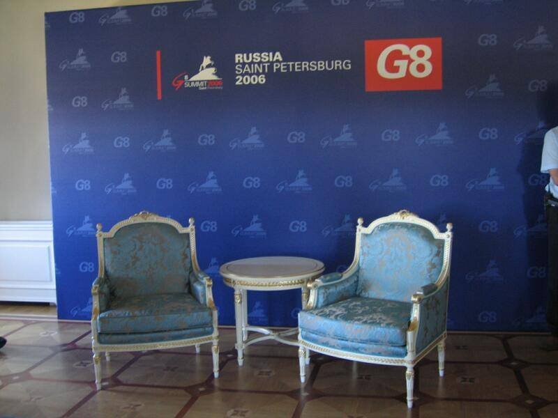 Саммит G8 в Санкт-Петербурге 2006: два кресла и столик перед фоном с логотипом