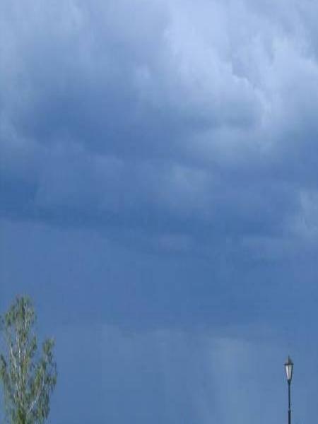 Парк у воды под тёмным небом с грозовыми облаками