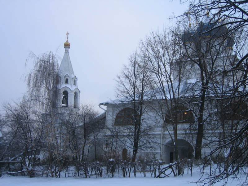 Зимний вид белокаменного храмового комплекса с колокольней и куполами