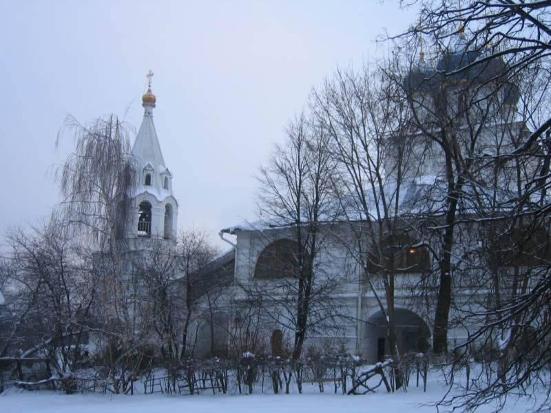 Зимний вид белокаменного храмового комплекса с колокольней и куполами
