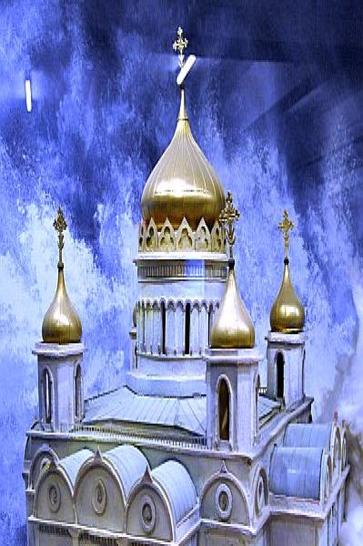 Модель православного храма с золотыми куполами на фоне облаков