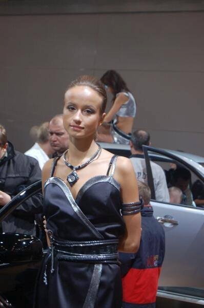 Моторшоу-2006, Москва: модель в чёрном на фоне серебристого авто