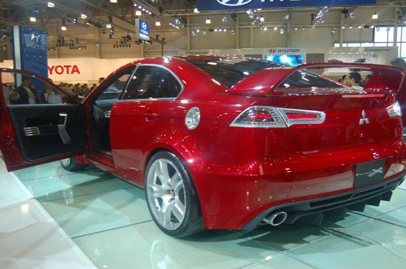 Красный спортивный автомобиль Mitsubishi на автосалоне с открытыми дверями