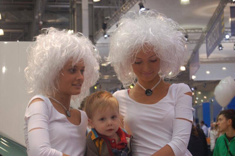 Motorshow 2006: две женщины в белых париках и мальчик на фоне выставочного зала