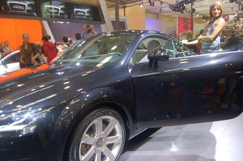 Моторшоу-2006: чёрный Audi TT с открытым дверным проёмом на фоне оживлённой выставки