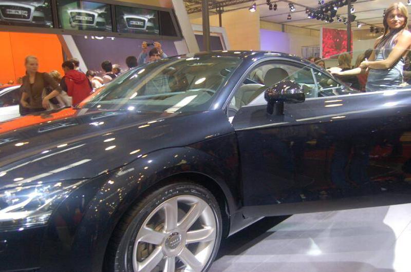 Моторшоу-2006: чёрный Audi TT с открытым дверным проёмом на фоне оживлённой выставки