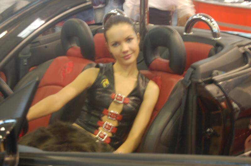 Motorshow 2006, Москва: женщина в кожаном жилете с красными пряжками на сиденье кабриолета