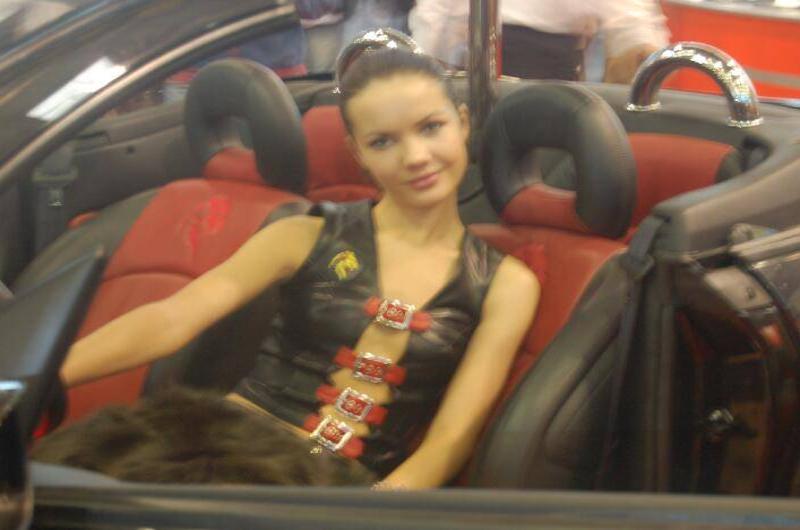 Motorshow 2006, Москва: женщина в кожаном жилете с красными пряжками на сиденье кабриолета