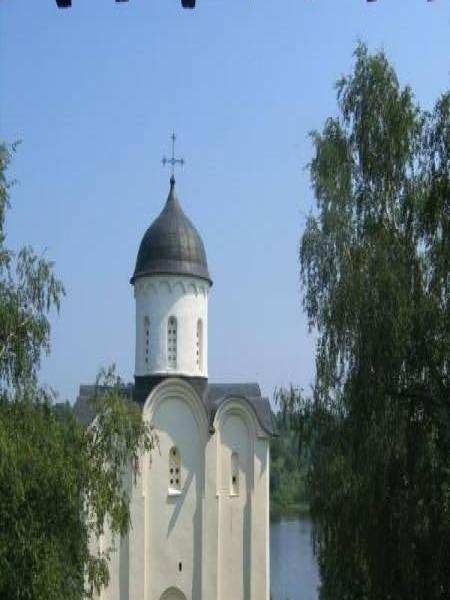 Белокаменная церковь с черным куполом у воды под деревянным навесом