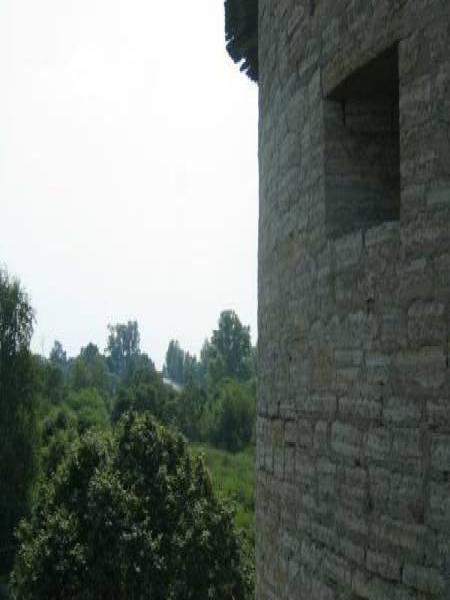 Старая Ладога, 2006: каменная башня с узким окном и соломенной крышей