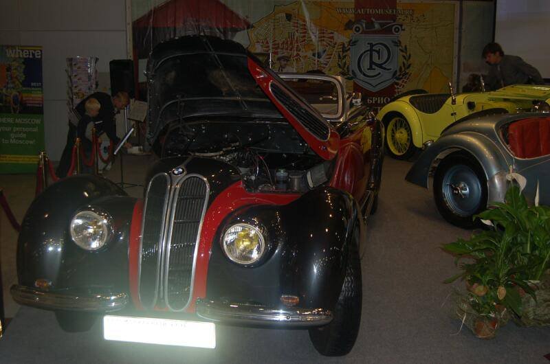 Oldtimer 06 2: чёрно-красный BMW с поднятым капотом в зале выставки