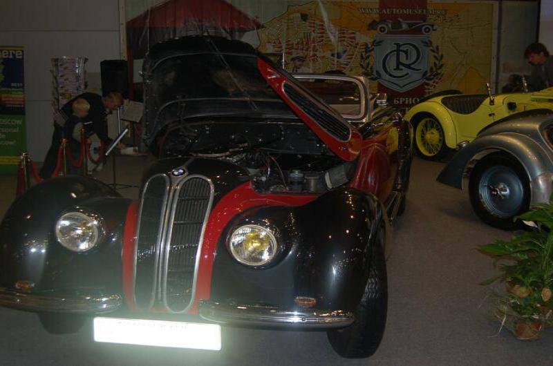 Oldtimer 06 2: чёрно-красный BMW с поднятым капотом в зале выставки